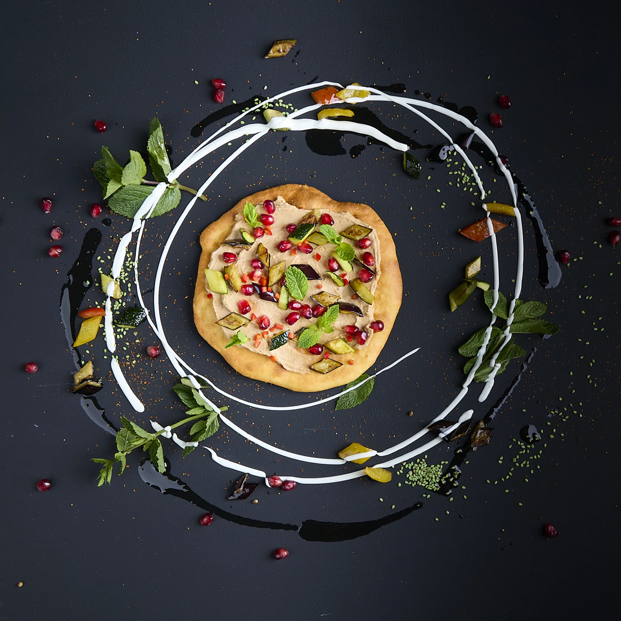 Belegtes Flatbread mit bedda Frischcreme Orientalische Dattel, Paprika, Aubergine, Zucchini, Granatapfelkernen, Minze und Spinat