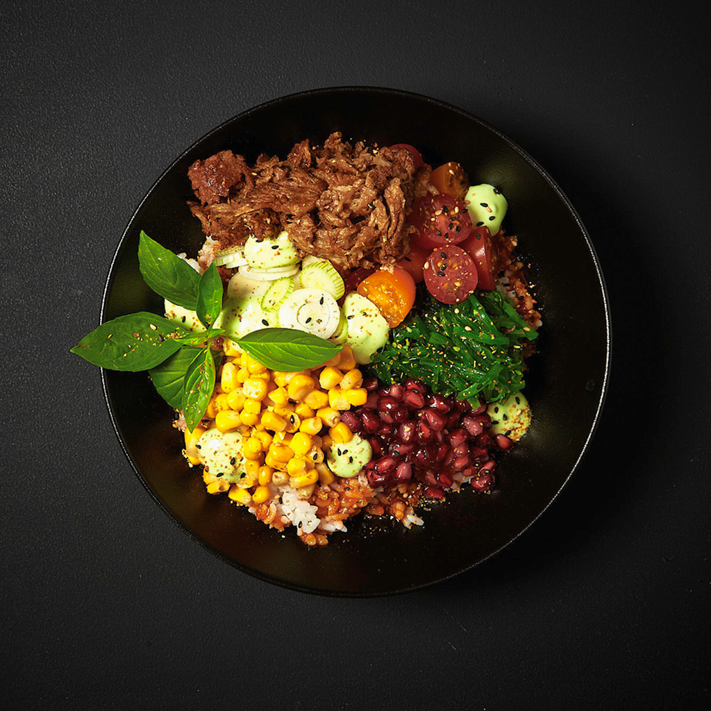 Frisch angerichtete Hot Bowl Creation Ying Yang mit knackigem Gemüse, Reisbasis, würzigen Toppings und asiatisch inspirierter Sauce in einer Buddha Bowl serviert.