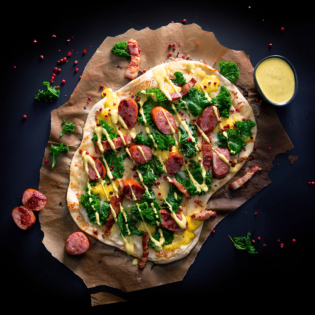 Frisch gebackener Flammkuchen Style Nordisch mit knusprigem Boden, nordisch inspirierten Zutaten, frischen Toppings und cremiger Sauce auf einem Brett serviert.