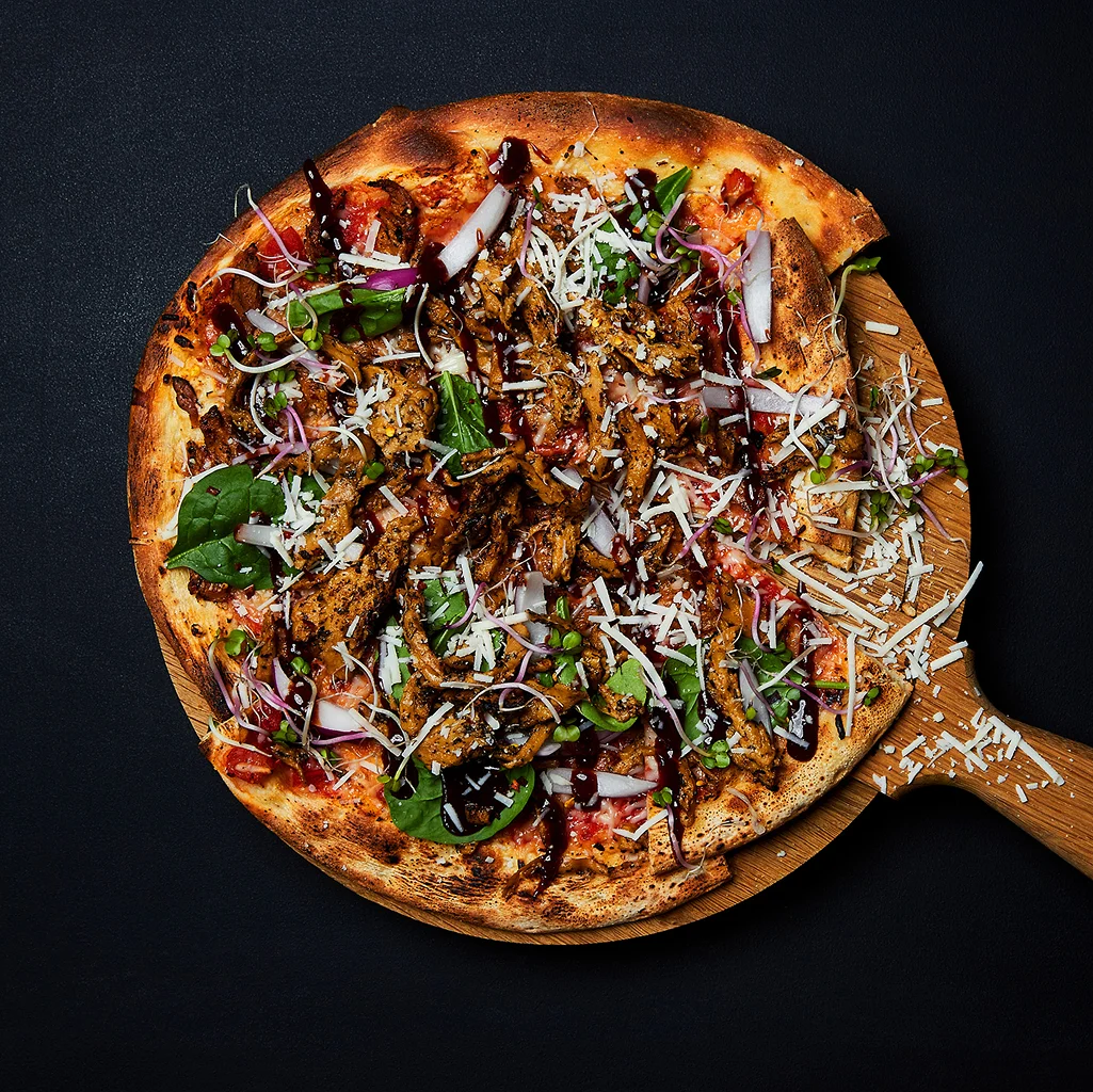 Frisch zubereitetes Crunchy BBQ Dough mit knusprig gebackenem Teig, würzigen BBQ-Zutaten und aromatischen Toppings auf einem Teller serviert.